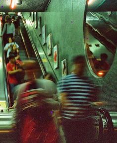 several people are riding down an escalator