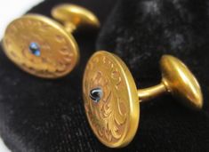 Now here's one sharp looking pair of antique cufflinks! Ready to dress up your finest attire. These beauties date from the late 1800's time period. Made of 14K yellow gold. The pair is hallmarked and has been tested to ensure the golds purity. Wonderful foliage and floral motifs adorn the main panel. In its center is a lovely tiny sapphire cabochon stone. The ovals measure 11/16 of an inch by 7/16 of an inch. The center bar is approximately 3/8 of an inch long. Ends are engraved with the letters Formal Antique Gold Jewelry Stamped 14k, Victorian Engraved Earrings For Formal Occasions, Victorian Screw Back Jewelry For Formal Occasions, Victorian Formal Jewelry With Screw Back, Victorian Screw Back Earrings For Formal Occasions, Antique Screw Back Earrings For Formal Occasions, Antique Formal Earrings Stamped 14k, Antique Stamped 14k Formal Earrings, Formal Oval Jewelry With Maker's Mark