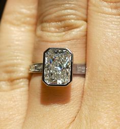 a woman's hand with a diamond ring on it