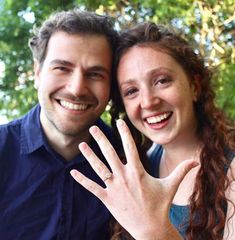 a man and woman posing for the camera with their hand up in front of them