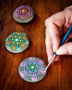 someone is painting rocks with beading on them