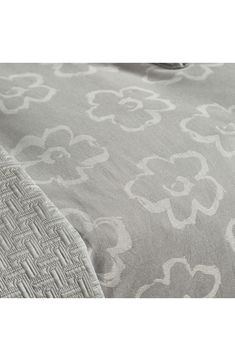 an image of a bed with grey and white bedspread