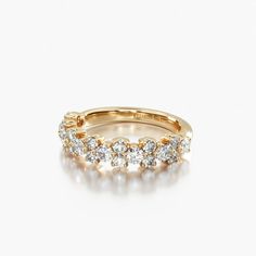 a yellow gold ring with five diamonds on the side and two rows of white stones in the middle