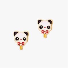 a pair of panda bear earrings with red bows on their ears and eyes, sitting in front of a white background