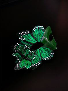 This striking handmade mask features intricate emerald green butterfly wings adorned with delicate white accents, creating a captivating whimsical look. Perfect for masquerade balls, costume parties, or any special occasion, the Emerald Butterfly Masquerade enhances your ensemble with its unique charm. Age Group/Gender - Adult/Women Size/Type - One size fits all adults Mask Color - Emerald Green Butterfly Color - Emerald Green Mask Material - polyresin Accent Material - butterflies made of feath Green Halloween Cosplay Mask, Green Masks For Carnival Costume Party, Green Masquerade Mask For Mardi Gras, Green Masks For Mardi Gras Carnival, Green Masquerade Mask For Mardi Gras Party, Green Halloween Costume Party Mask, Green Masks For Carnival Masquerade, Green Masks For Masquerade Carnival, Green Mask For Masquerade Carnival