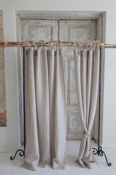 the curtains are hanging in front of an old door