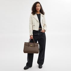 Our Broome has all the effortless cool of its namesake Soho street. The spacious foldover silhouette is crafted of luxe refined leather with a high shine finish and secures with our pushlock “C” closure. Featuring pockets inside and out for easy organization and room for a 16” laptop carry it by hand or use the detachable strap to wear it crossbody. | Coach Broome Carryall Bag 36 - Women's - Brass/dark Stone Chic Bags With Cc Turnlock Closure And Double Flap, Chic Double Flap Bag With Cc Turnlock Closure, Elegant Double Flap Soft Leather Bag, Business Flap Bag With Cc Turnlock Closure, Business Flap Bag With Designer Lock Closure, Chic Business Flap Bag With Cc Turnlock Closure, Designer Double Flap Everyday Bag, Designer Everyday Double Flap Bag, Timeless Flap Bag With Cc Turnlock Closure