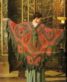 a woman wearing a red and green crocheted shawl with an intricate design