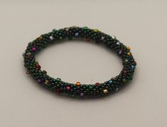 Made from a FusionBeads pattern, this fun bangle is made with bead crochet. Shiny green beads are accented with larger multicolored beads to resemble a sparkling wreath. Crocheted with red bead thread. These bracelets roll on & have some flex when rolling them on, so the widest part of your hand should be no more than 8" around. Green Beads, Bead Crochet, Red Bead, Green Bead, Roll On, No More, Wreath, Bangles, Thread