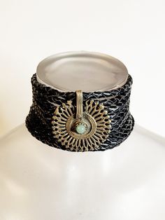 Discover the enchanting allure of our one-of-a-kind bohemian choker, meticulously handcrafted for the empowered woman with a penchant for unique style. This exquisite piece features a vegan braided leather band that gracefully adorns your neck, offering a comfortable and ethical fashion choice. At the heart of the choker lies an antique tribal central piece, boasting a stunning piece of jade with a rich history that adds depth and storytelling to your ensemble. Measuring at a versatile length, t Black Bohemian Bracelet Jewelry, Handmade Bohemian Brass Choker, One-of-a-kind Adjustable Choker Necklace, One Of A Kind Adjustable Choker Necklace, Bohemian Metal Choker As Gift, Black Bohemian Hand-wrapped Jewelry, Black Bohemian Hand Wrapped Jewelry, Adjustable Bronze Bohemian Bracelets, Bohemian Black Hand Wrapped Jewelry