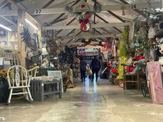 the inside of a store with lots of items on display and people walking through it