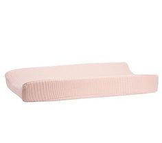 a pink pillow sitting on top of a white surface