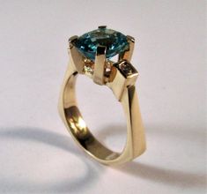 A 14kt yellow gold original designer ring Center stone is a 10x8 mm oval Swiss blue topaz Side diamonds are two round 2.5mm si1 g/h color tdw .14cts Can be ordered in white gold, yellow gold, rose gold, and platinum Comes in all sizes Comes in a beautiful box 100% MONEY BACK GUARANTEE Modern Topaz Ring With Center Stone In Yellow Gold, Modern Yellow Gold Topaz Ring With Center Stone, Modern 14k Gold Topaz Ring, Modern Oval Sapphire Ring With Tension Setting, Modern Topaz Ring With Center Stone For Anniversary, Modern Yellow Gold Blue Topaz Ring, Modern Oval Blue Topaz Ring, Elegant Oval Topaz Ring With Tension Setting, Modern Gold Topaz Ring With Center Stone