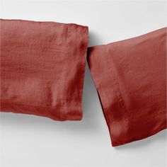 two red linen pillows sitting next to each other