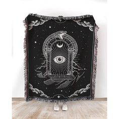 a black and white tapestry with an all seeing eye in the sky on it's side