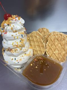 an ice cream sundae, waffles and caramel sauce in a plastic container