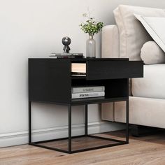 a nightstand with books on it next to a couch