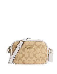 coach handbag in beige and white with the strap down to it's shoulder