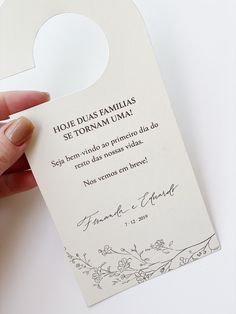 a person is holding up a white door hanger with the words hol - dus familias se tonnam uma