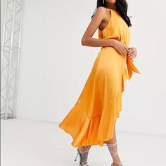 a woman in an orange dress posing for the camera