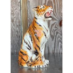 a tiger figurine sitting on top of a table next to a wooden wall