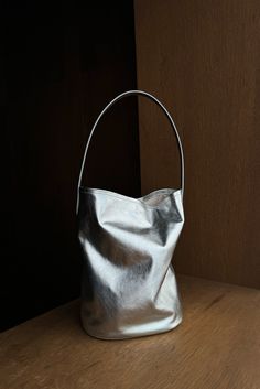 Silver leather bucket bag featuring a scrunch silhouette and tall top handle. Inside features tie strap for closure and is lined with cotton. Fit True to size Composition 100% Leather (Outer) 100% Cotton (Inner) This product is final sale Round Bucket Bag, Silver Pouch Bag, Mood Inspiration, Leather Basket, Barrel Bag, Leather Bucket Bag, Leather Bucket, Nylon Bag, New Arrival Dress