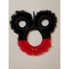 a pair of black and red eye masks hanging on a wall