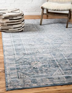 an area rug with blue and white colors on the floor in front of a chair