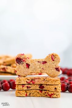 two cookies stacked on top of each other with cranberries around them