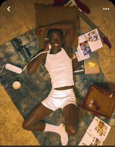 a woman laying on the floor with her feet up and headphones in her ears