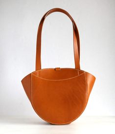 Tote bag in original design, for your everyday use, from Tuscan vegetable tanned leather Vera Pelle. It can be carried in the hand or on the shoulder. *Material: genuine Italian leather of vegetable tanning, Italian fittings. *Color: tan. Dimensions: 12.6”(2cm) x 9.4”(24cm) x 4.7”(12cm), (under the handle 10”(26cm). *Inside: one compartment, one accessory pocket. The bag closes with a holster button. *100% Handmade. *Bag stitched by hands saddle seam - most reliable and strong seam. Edges polish Funky Handbags, Tote Leather Bag, Handbag Handles, Handmade Bag, Womens Tote, Vegetable Tanned Leather, Leather Handbag, Fashion Handbags, Leather Craft