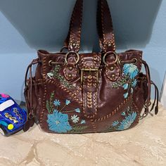 Very Good Condition Inside And Out Normal Vintage Wear 18" W X 12" H X 5" D 2 Side Pockets With Leather Tassels With Floral Embellishment Inside 1 Zip Pocket And 3 Slip Pockets Large Heavy Sturdy Bag Embroidered Brown Hobo Shoulder Bag, Embroidered Brown Tote Hobo Bag, Brown Embroidered Hobo Shoulder Bag, Embroidered Brown Hobo Tote Bag, Embroidered Brown Hobo Bag, Embroidered Brown Tote Satchel, Brown Shoulder Bag With Floral Embroidery For Daily Use, Brown Embroidered Tote Satchel, Brown Floral Embroidered Shoulder Bag For Daily Use