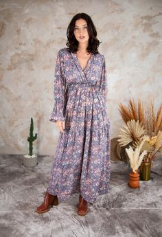 "Make a statement with our Jasmine Boho Maxi Dress. With long sleeves and a modest V-neckline, this dress is perfect for any occasion. The high waist is elasticated for a comfortable fit, while the tiered skirt adds a playful touch. The purple floral print is eye-catching and unique.  It comes packaged in a beautiful recycled silk bag, making it a great gift for yourself or a loved one. Perfect for a summer wedding, a night out with friends, or even a casual day at the beach.  Available in three sizes Measurements  Small/Medium Length 52\"/132cm Bust 32\"/82cm Waist 28\"/71cm Hips max 44\" Sleeve Length 18\"/41cm Sleeve circumference 18\"/ Medium/ Large Length 54\"/137 cm Bust 36\"/91cm Waist 30\"/76cm Hips 50\"/127cm Sleeve Length 18\"/41cm Sleeve circumference \"/51cm Model height 5\"8 W Maxi Dress Modest, Style Ibiza, Maxi Dress With Long Sleeves, Boho Floral Maxi Dress, Modest Maxi, Ibiza Style, Purple Maxi Dress, Dress Modest, Purple Floral Print