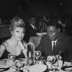 two people sitting at a table with wine glasses