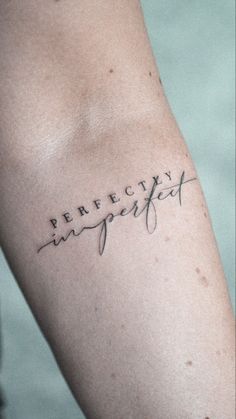 a person with a tattoo on their arm that says perfectly imperfected in cursive writing