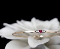 "My signature solitaire bangle, a timeless bracelet featuring a vibrant lab created Ruby, July's traditional birthstone. These gems exhibit a vivid and saturated magenta pink color and a semi-translucent body. The bracelet features a locking hook and eye closure. The gems used in this design measure approximately 3.5mm.  METAL OPTIONS  Select your choice from the dropdown menu. If the Two Toned option is selected please use the personalization field to specify your combination.  FINISH OPTIONS Elegant Red Bracelet With Birthstone, Elegant Red Birthstone Bracelet, Elegant Red Stackable Jewelry, 14k Gold Bangle With Single Diamond For Anniversary, Anniversary 14k Gold Bangle With Single Diamond, Classic Birthstone Bracelets For Anniversary, Wedding Fine Jewelry Bracelet With Birthstone, Classic Gemstone Bangle For Anniversary, Classic Ruby Bracelet As Gift