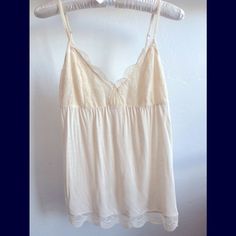 Soft Camisole With V-Neck Lace Bust. Inside Bust Area Is Lined With Soft Rayon Fabric. Scallop Hem. The Body Is Also Rayon. Adjustable Straps In Back.