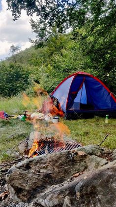 a tent is set up next to a campfire