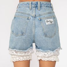 "Vintage 80s cut off denim shorts in blue denim with lace trim. Every garment we sell is authentic vintage and one-of-a-kind! You will receive the exact item photographed. Condition: Very good vintage. Has a couple faint spots that should come out with cleaning. Best fits women's: Extra small/24 Material: denim MEASUREMENTS Taken from seam to seam while the garment is lying flat. Double the armpit, waist, and hips For reference, model is 5'10\" and measures 31-23-34. Waist: 12\" Hips: 19\" Insea Vintage Bottoms With Lace Trim For Summer, Vintage Lace Trim Bottoms For Summer, Denim Bottoms With Lace Trim For Summer, Lace Trim Shorts For Spring, Summer Denim Bottoms With Lace Trim, Y2k Medium Wash Cutoff Shorts, Vintage Denim Blue Cutoff Jean Shorts, 80s Denim Shorts, Vintage Short Denim Blue Bottoms