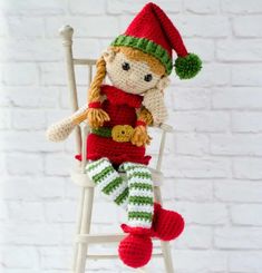 a knitted doll sitting on top of a white chair