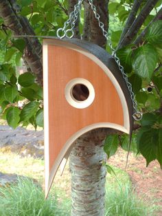 a wooden birdhouse hanging from a tree