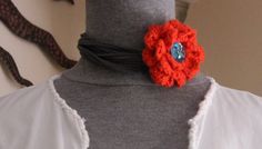 a close up of a mannequin's neck with an orange flower on it