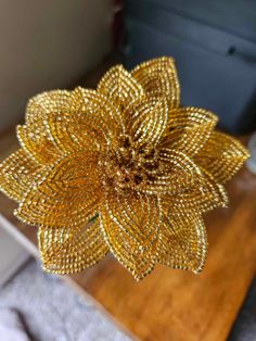 a gold flower is sitting on top of a table