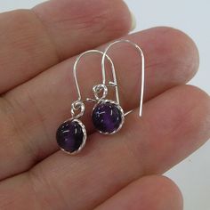 "Smooth purple amethyst 6mm beads, surrounded by sterling silver twist wire. Sweet! Small enough to wear every day, these earrings measure 7/8\" long including the sterling silver earwires. Amethyst is the February birthstone. This would make a perfect, affordable gift for that February girl, young or old! Also available in 14kt gold filled." Nickel-free Purple Dangle Hoop Earrings, Purple Adjustable Drop Crystal Earrings, Purple Dangle Hoop Earrings With Ear Wire, Purple Nickel-free Dangle Hoop Earrings, Handmade Purple Sterling Silver Earrings, Purple Dangle Hoop Earrings, Nickel-free Round Purple Earrings, Elegant Amethyst Dangle Hoop Earrings, Nickel Free Amethyst Dangle Earrings