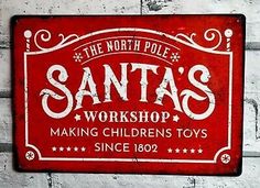 a red sign that says santa's workshop making children toys since 1932 on a white brick wall