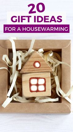 a wooden house in a box with ribbon around it and the words 20 gift ideas for a housewarming