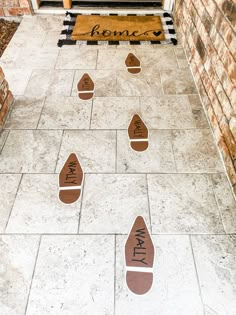 some brown and white footprints on the ground in front of a building with a welcome mat