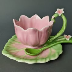 a pink and green flower shaped tea cup on a leafy saucer with matching saucer