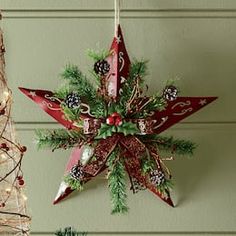 two christmas decorations hanging from the ceiling in front of a green wall and a red star