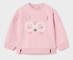 a pink sweatshirt with an owl applique on the chest and two eyes at the front